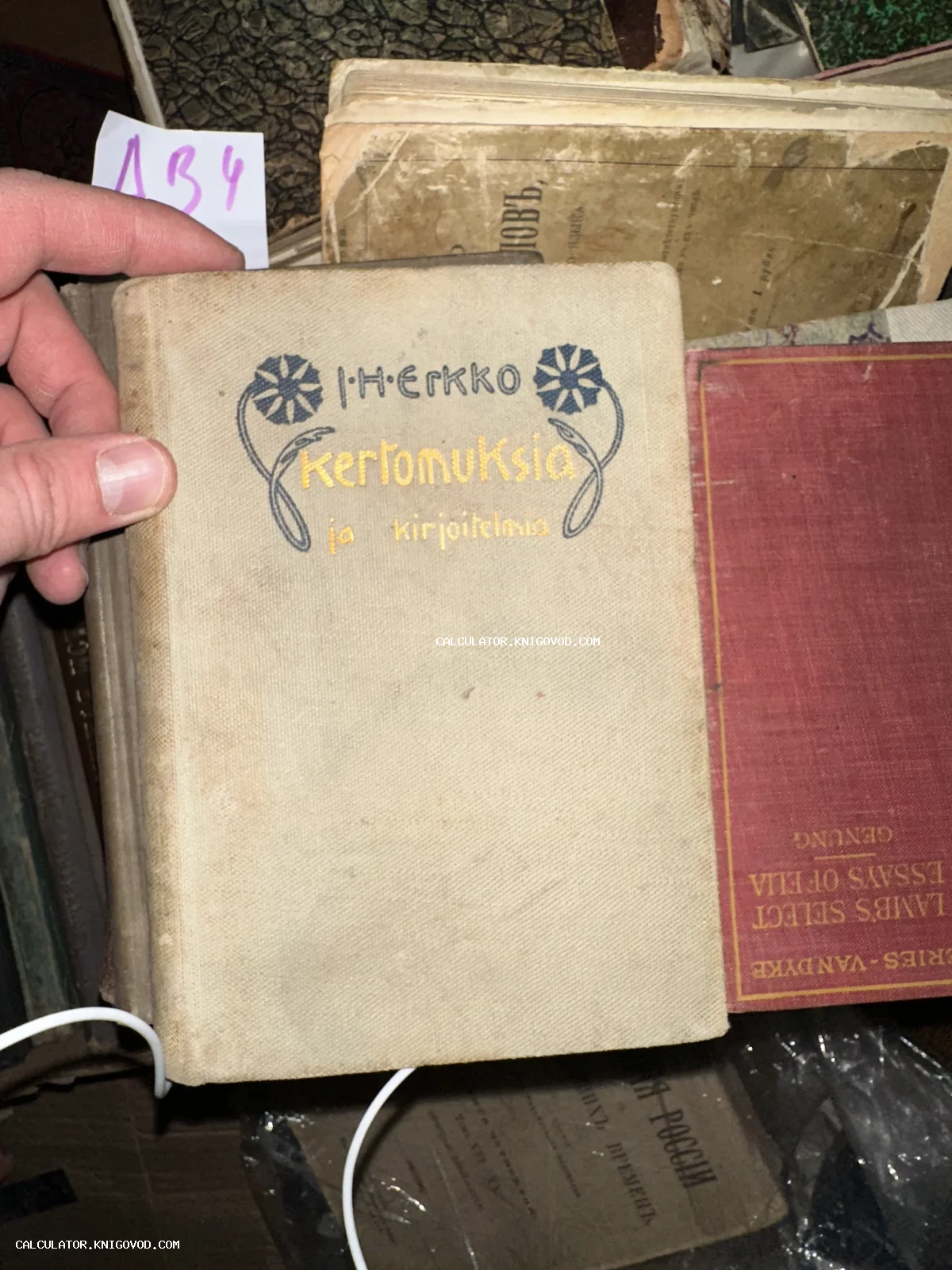 Старинная книга финского автора Ю. Х. Эркко в светлом тканевом переплете с синим и желтым тиснением.