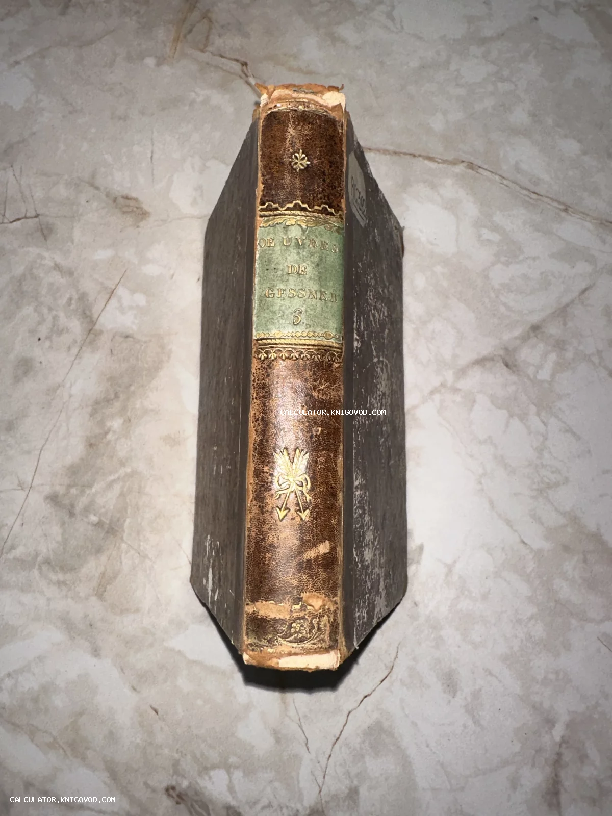 Корешок старинной книги в кожаном переплете с золотым тиснением и зеленой вставкой с надписью Oeuvres de Gessner.