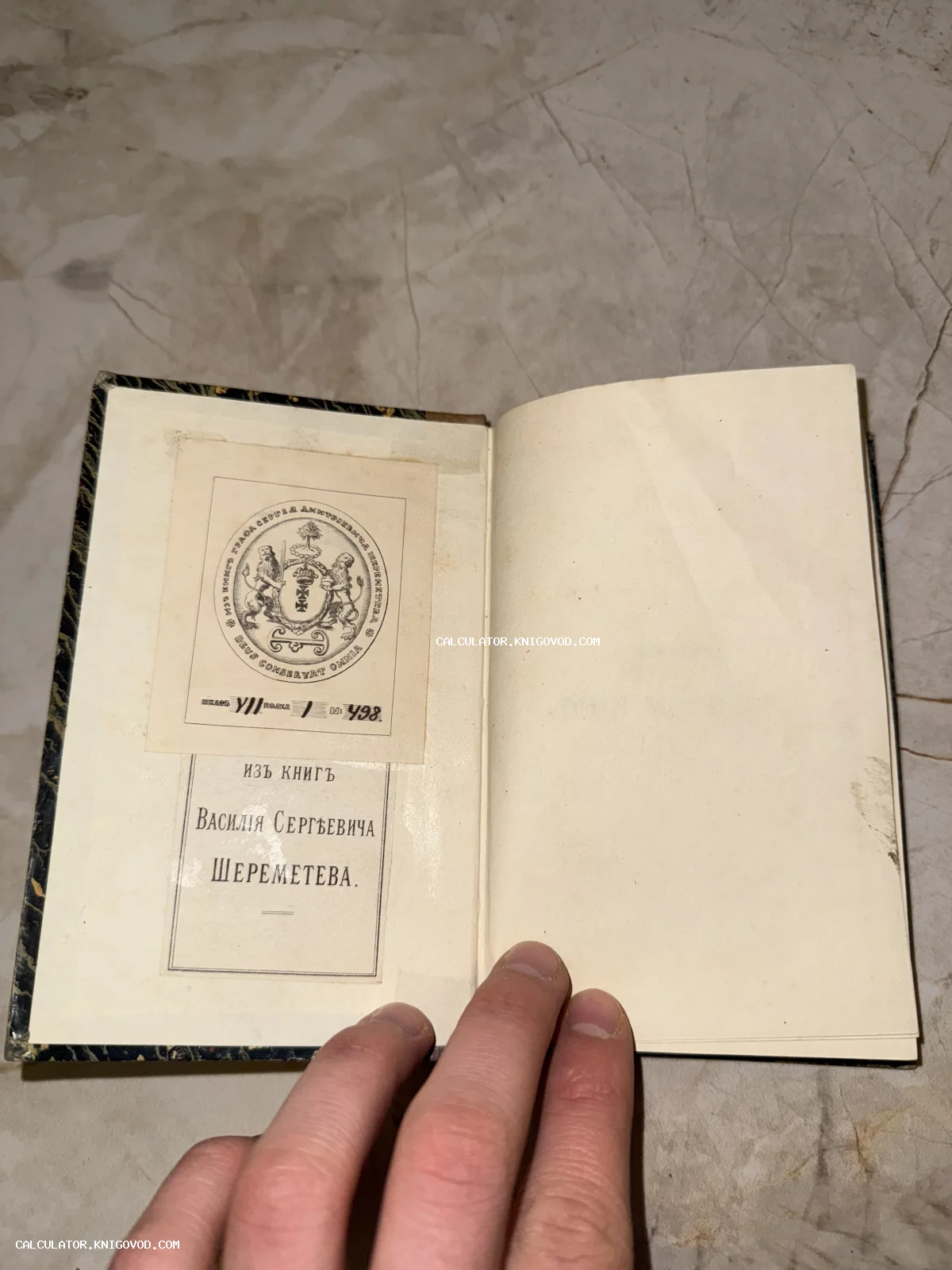 Разворот старинной книги с дворянским гербовым экслибрисом рода Шереметевых и инвентарными пометками.