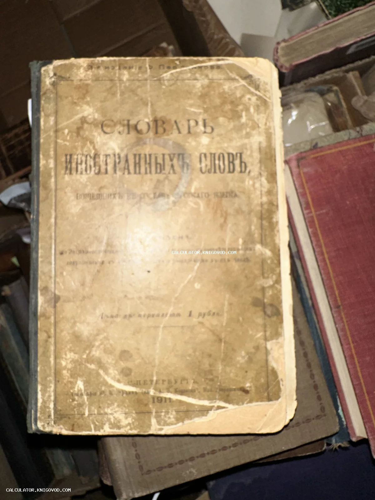Старинная книга с надписью «Словарь иностранных слов», изданная в 1911 году в Санкт-Петербурге, в потертом переплете.