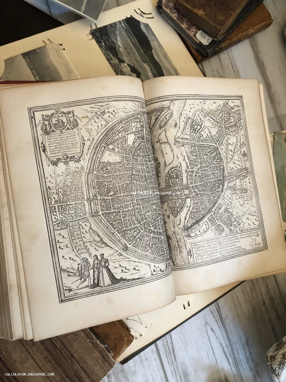 Раскрытая антикварная книга с детализированным круговым планом города, рекой Сеной и гербом в углу.