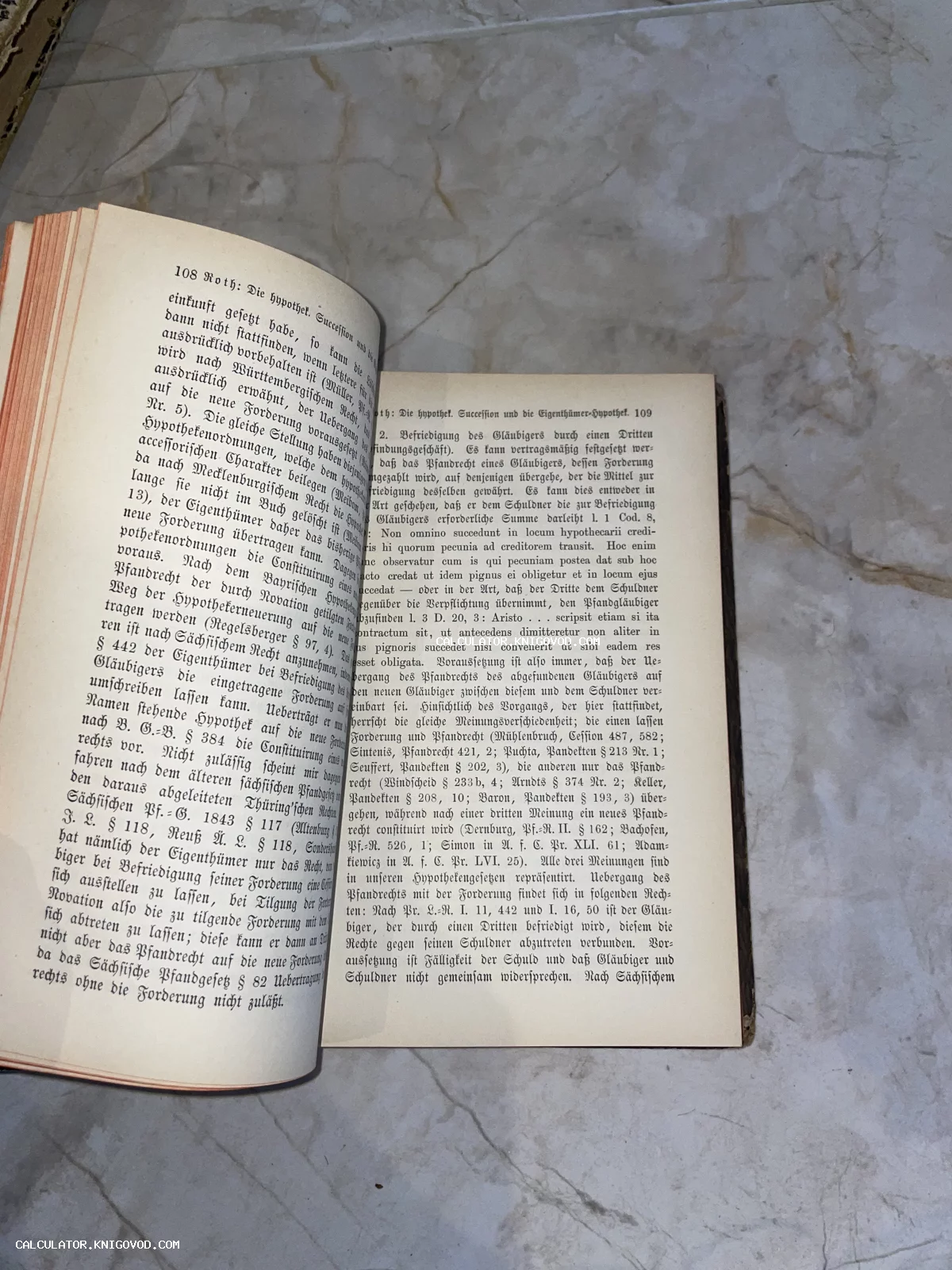 Разворот старинной книги с немецким готическим шрифтом на светлом мраморном фоне.