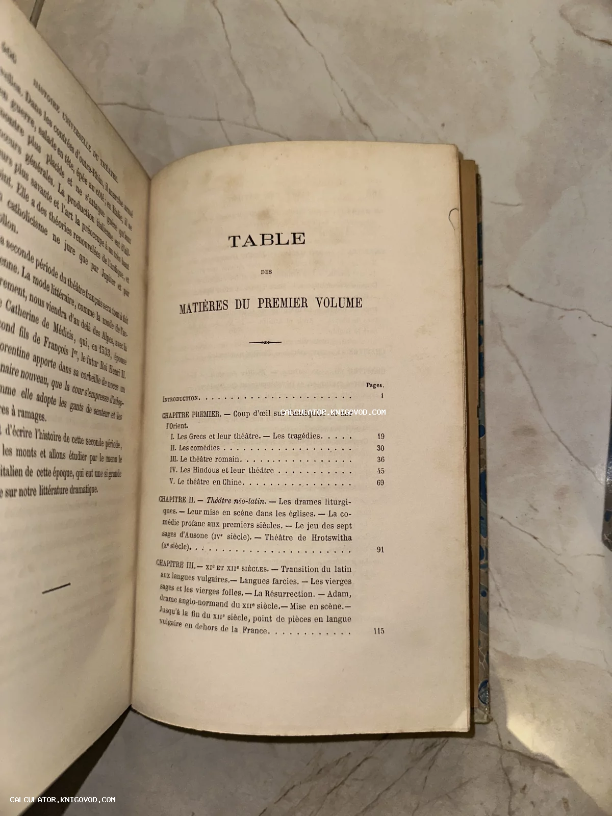 Разворот старинной книги на французском языке с оглавлением первого тома 'Histoire Universelle du Théâtre' на мраморной поверхности.