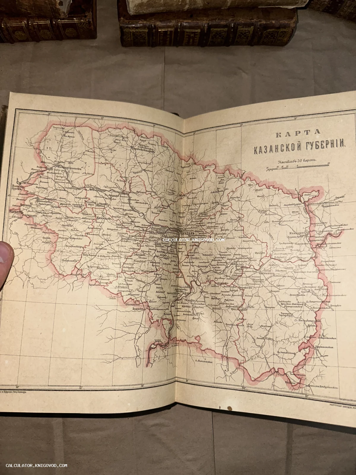 Разворот антикварной книги с подробной топографической картой Казанской губернии, выполненной в технике цветной литографии.