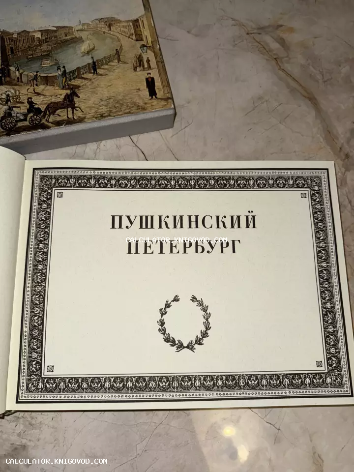 Титульный лист антикварного альбома «Пушкинский Петербург» с классическим орнаментом и лавровым венком, рядом виден иллюстрированный футляр.