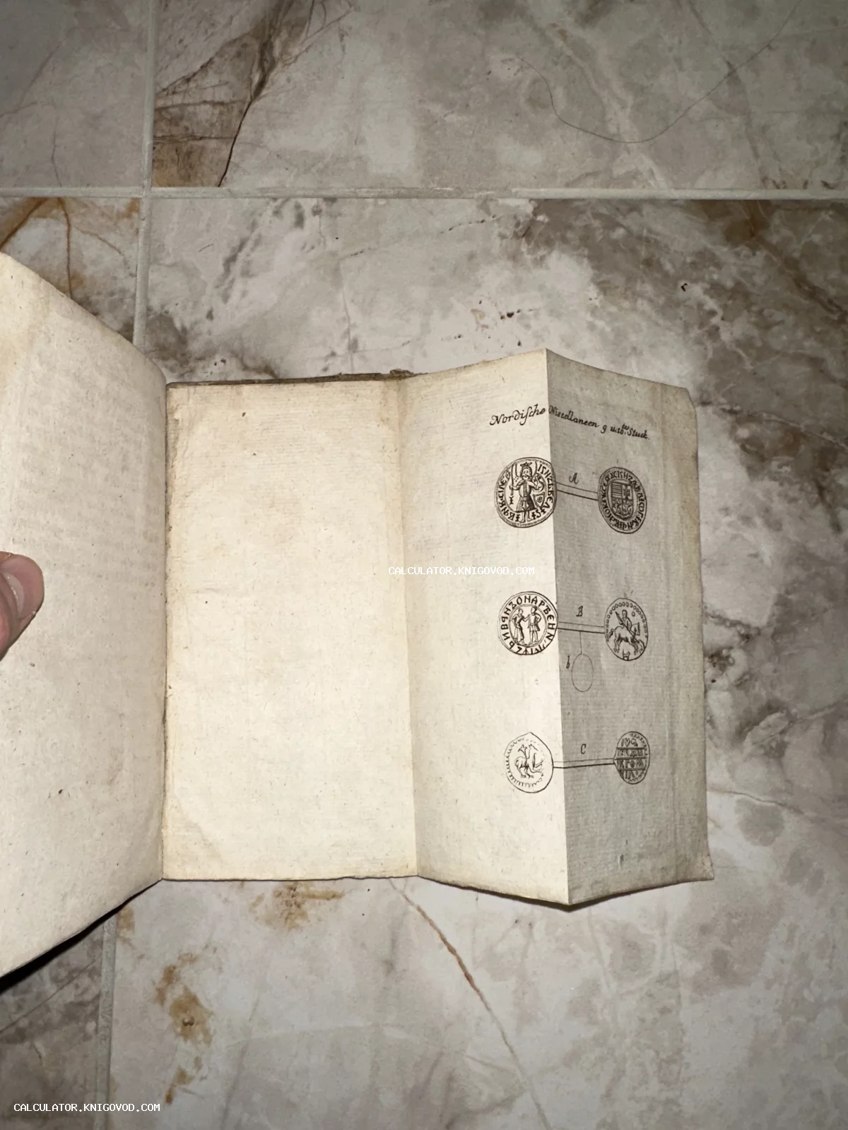 Разворот антикварной книги со складной иллюстрацией, на которой изображены старинные монеты и печати.