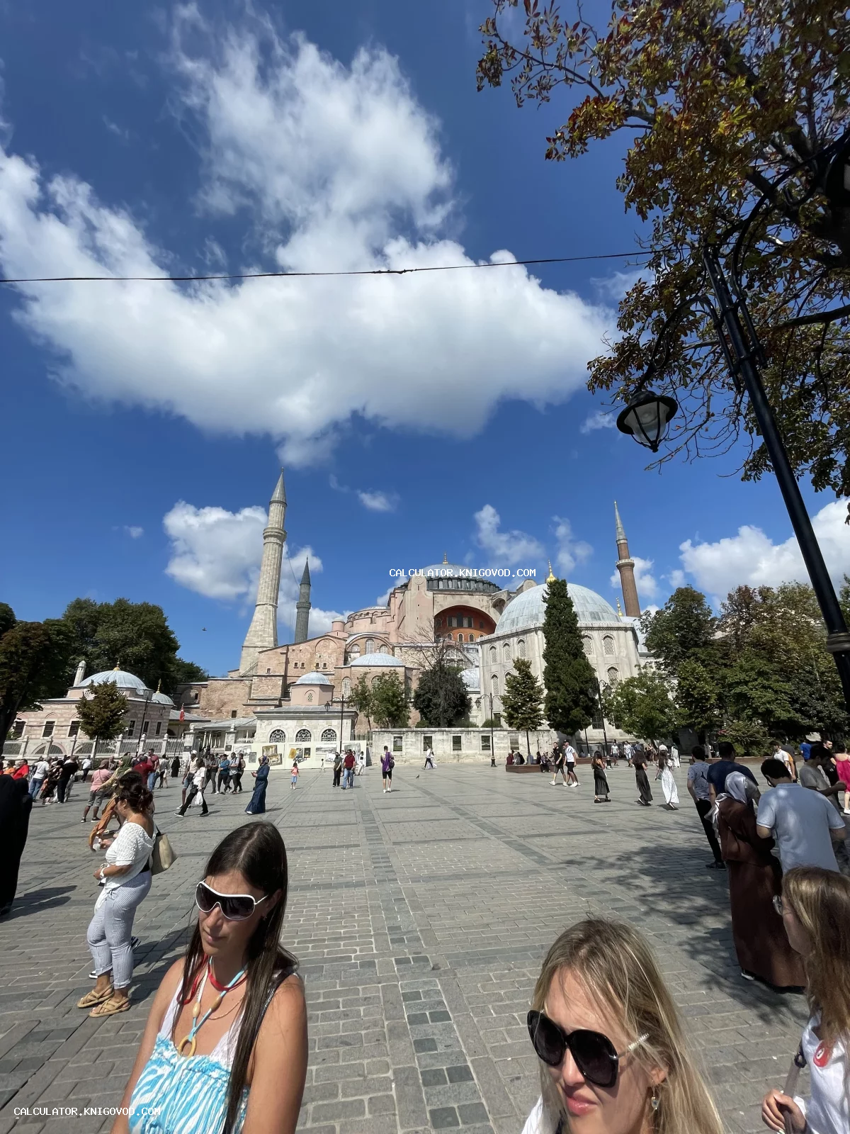 Вид на собор Святой Софии (Айя-София) с площади Султанахмет в солнечный день с туристами на переднем плане.