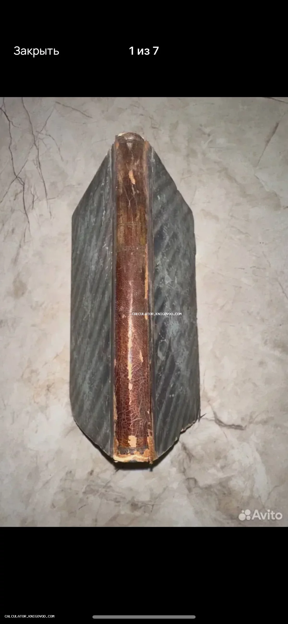 Корешок и часть обложки антикварной книги со следами износа и потертостями на коже.