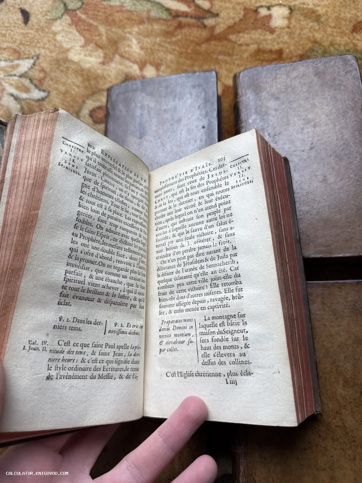 Разворот старинной книги на французском языке с теологическим текстом, пожелтевшими страницами и красным обрезом.