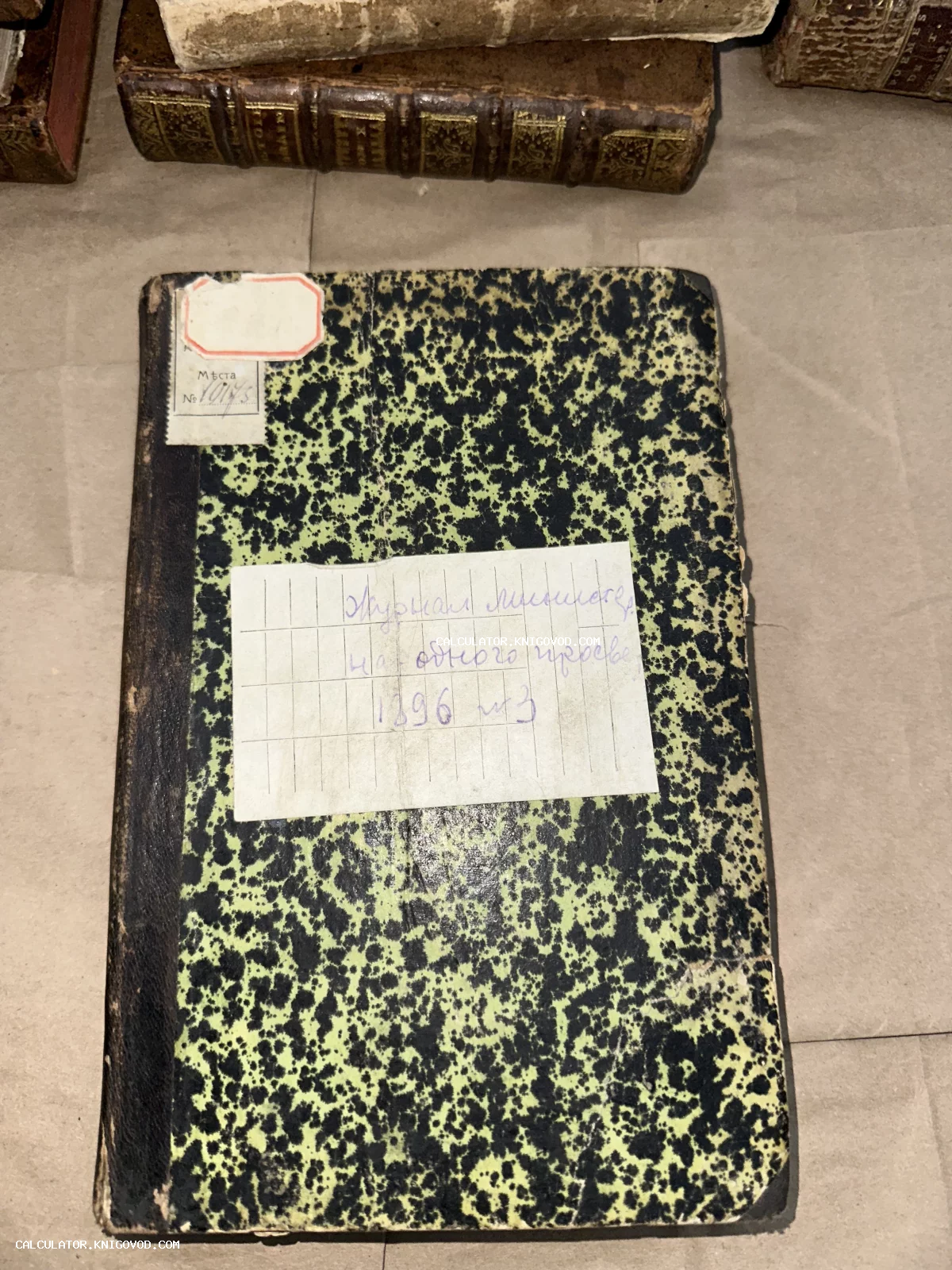 Старинная рукописная тетрадь в мраморном переплете с надписью 'Журнал личного состава одного полка 1896' на этикетке.