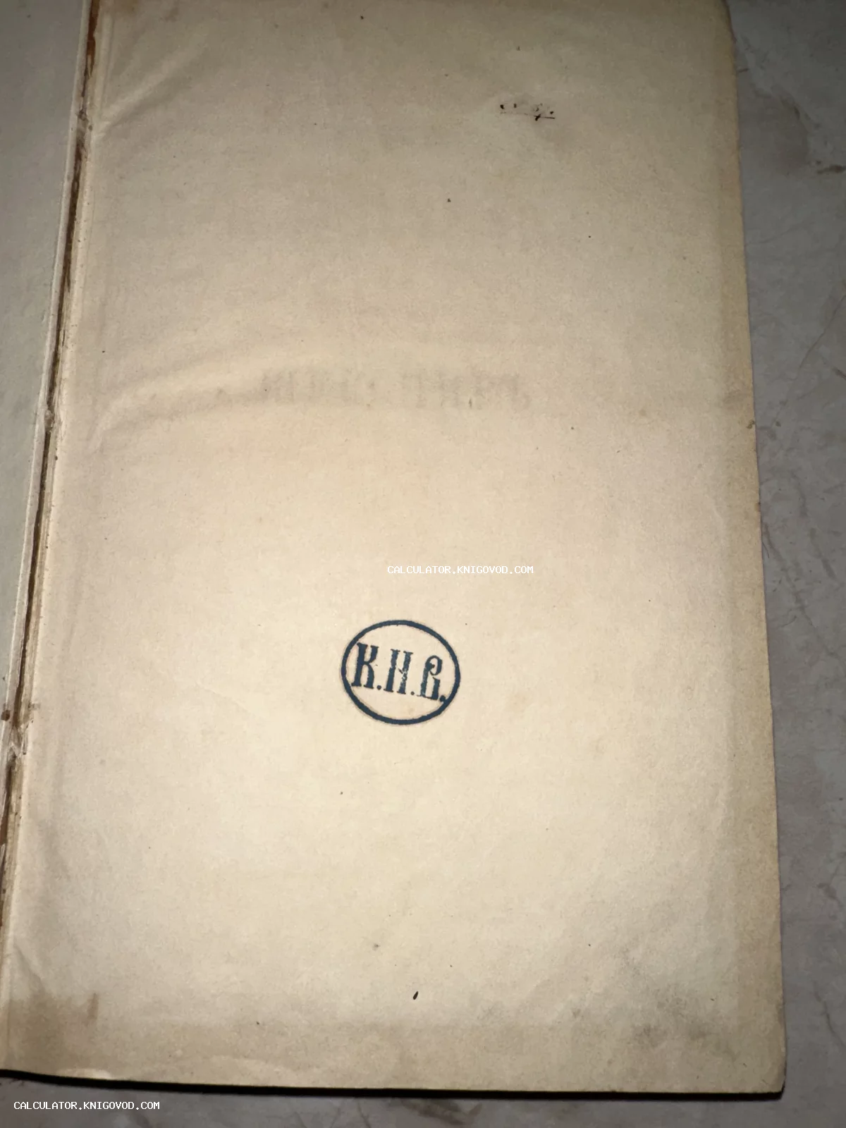 Пожелтевшая страница антикварной книги с круглым чернильным оттиском инициалов К.Н.В. в центре.
