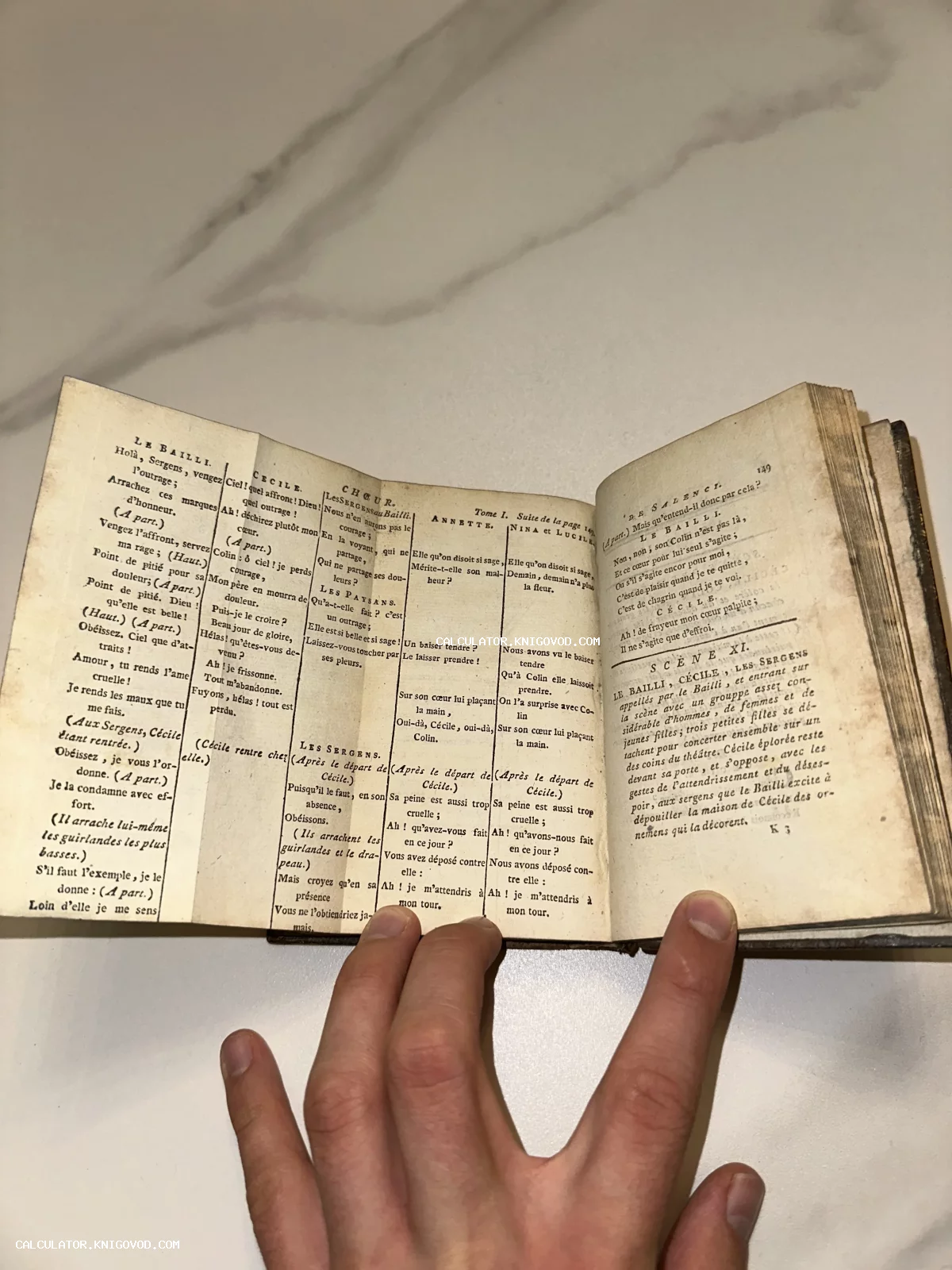 Разворот антикварной книги малого формата с французским текстом, пожелтевшими страницами и кожаным переплетом.