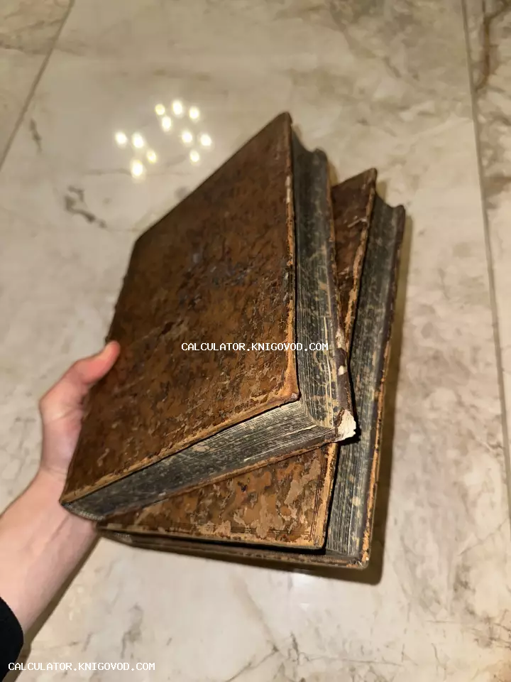 Три массивные старинные книги с потертыми обложками в руках человека на фоне светлого мрамора.