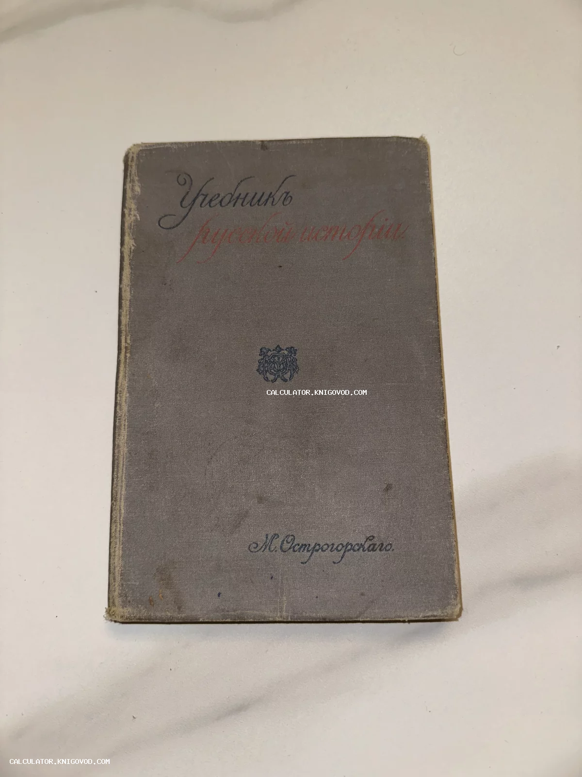 Старинная книга в сером тканевом переплете с названием «Учебник русской истории» авторства М. Острогорского.