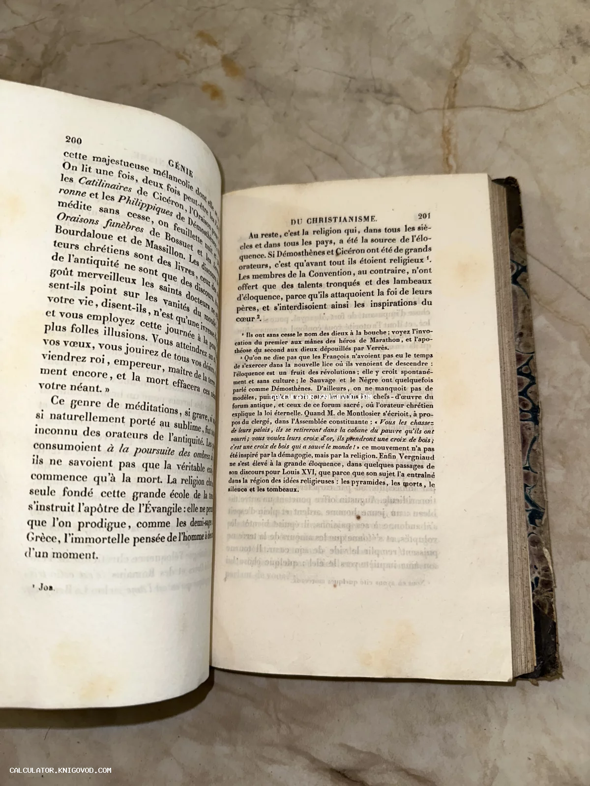 Разворот старинной книги на французском языке с пожелтевшими страницами и элементами мраморного переплета.