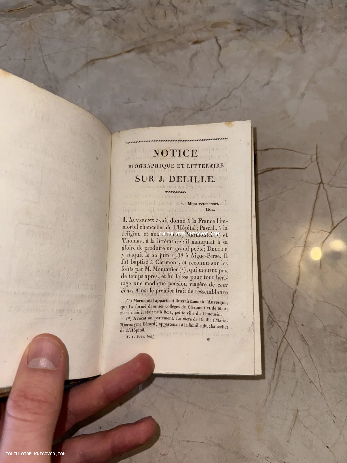 Разворот старинной книги на французском языке с биографическим очерком о Жаке Делиле на фоне мраморной поверхности.