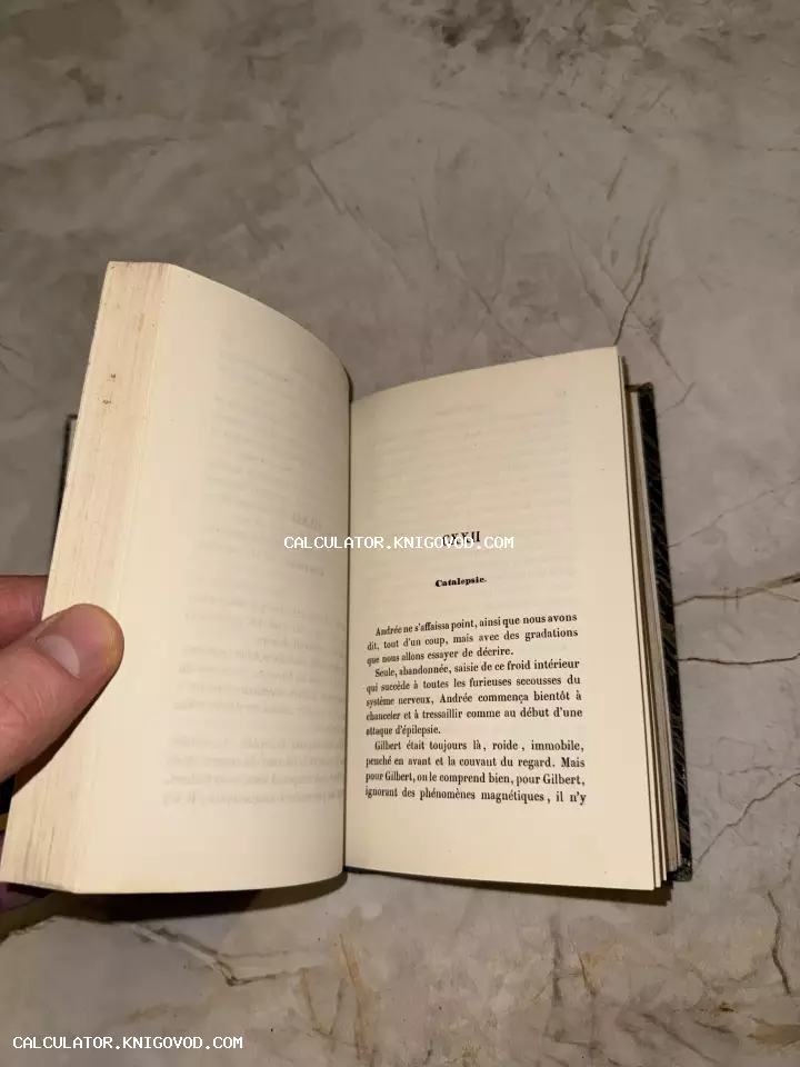Разворот старинной книги на французском языке с заголовком главы CXXII Catalepsie на фоне мраморной поверхности.