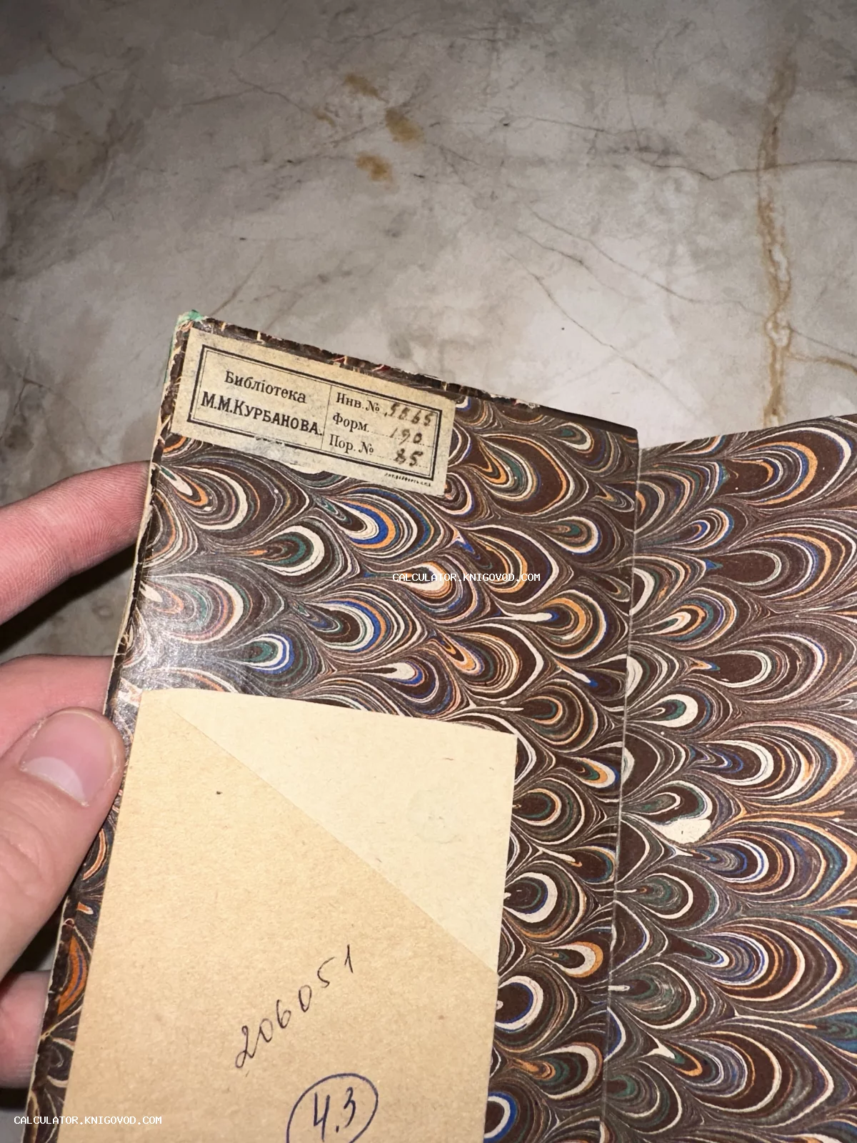 Форзац старинной книги с мраморной бумагой и наклеенным ярлыком личной библиотеки М.М. Курбанова.