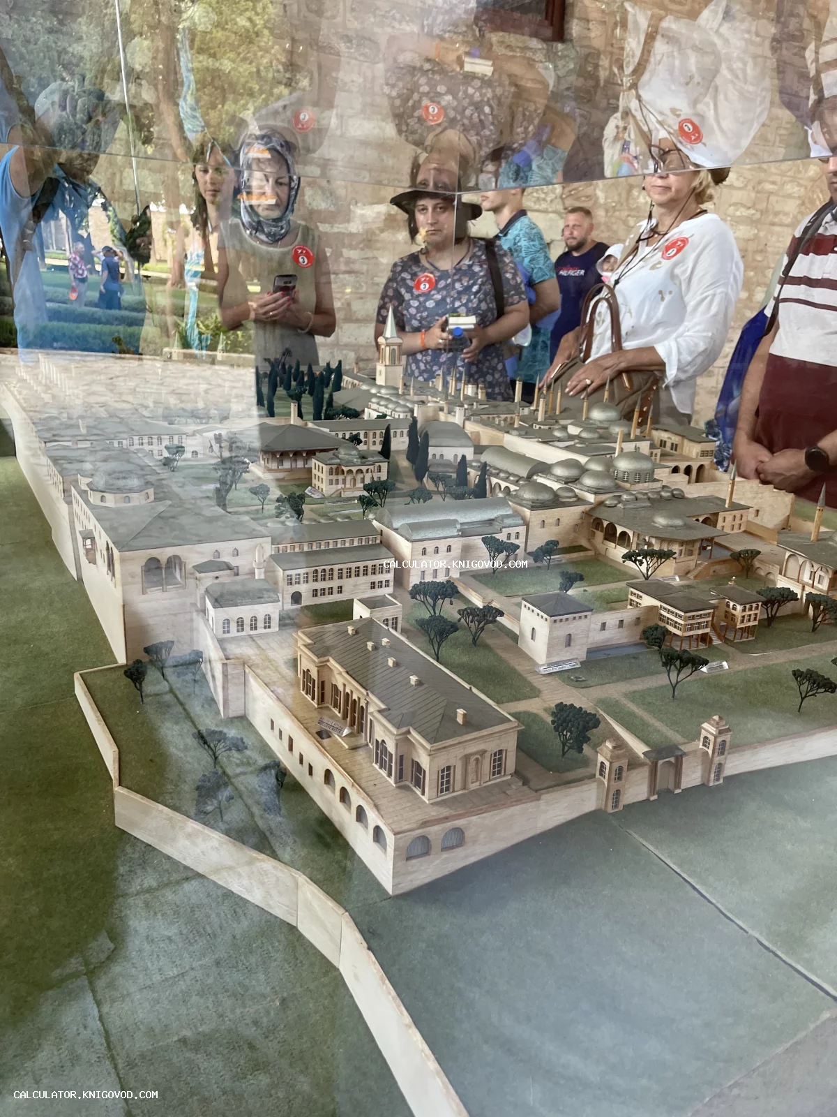 Детальный миниатюрный макет древнего восточного дворца с куполами и садами под стеклянной витриной в музее.