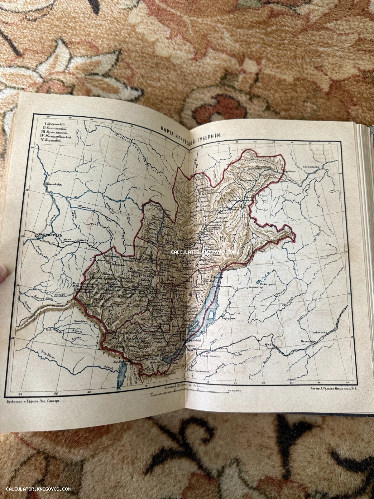 Разворот старинной книги с детальной цветной картой Иркутской губернии конца XIX века.