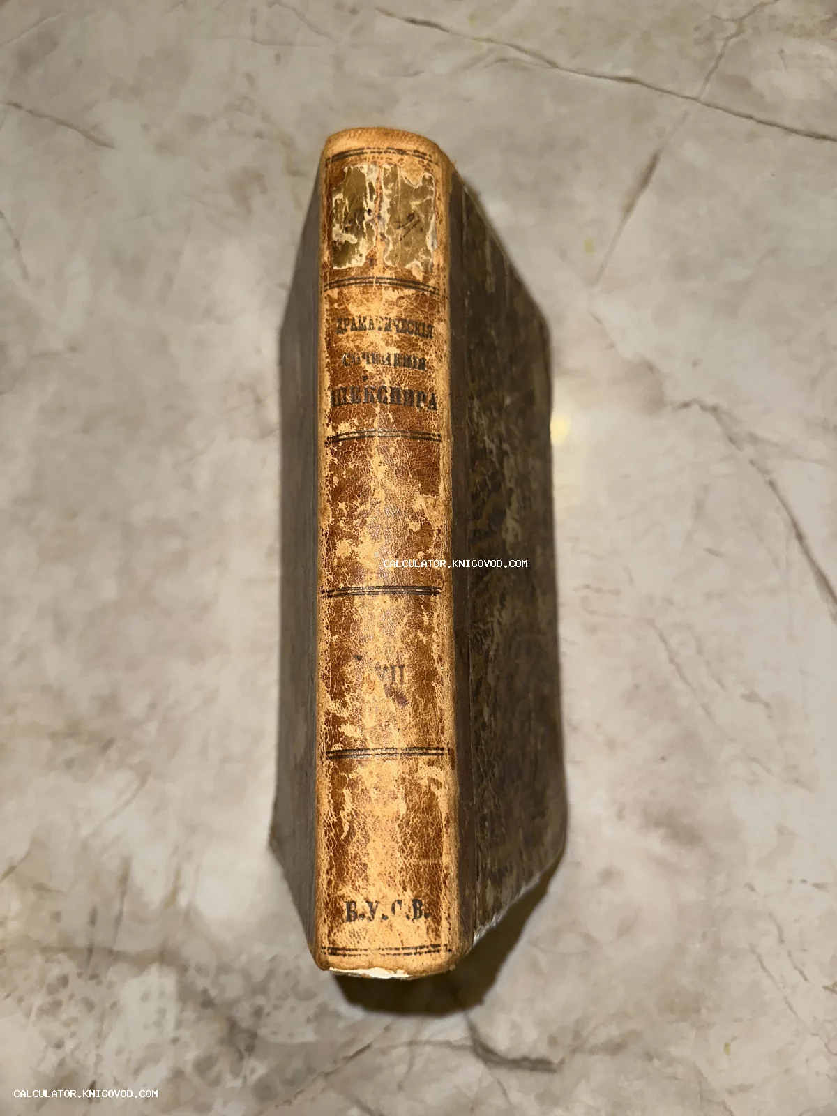 Корешок старинной книги с золотым тиснением «Драматические сочинения Шекспира», том VII, на фоне мраморной поверхности.