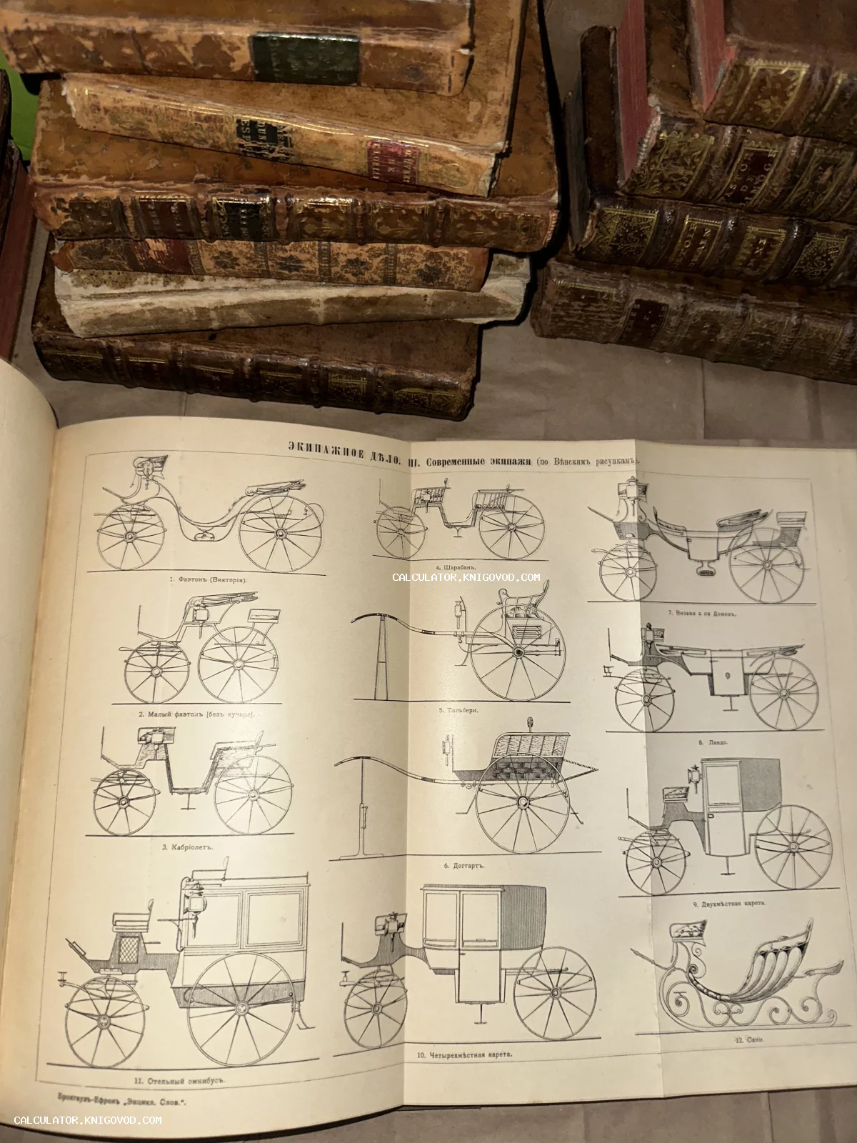 Разворот антикварной книги с чертежами различных видов конных экипажей и карет на фоне стопки старинных томов в кожаных переплетах.