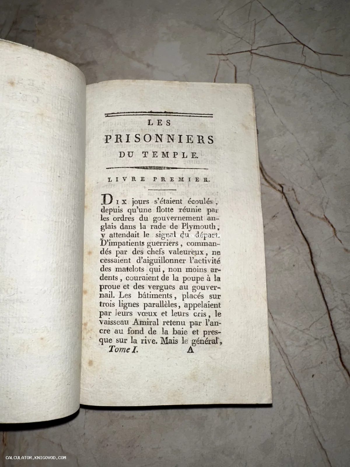 Разворот старинной книги XVIII-XIX века с французским текстом Les Prisonniers du Temple на фоне мраморного стола.