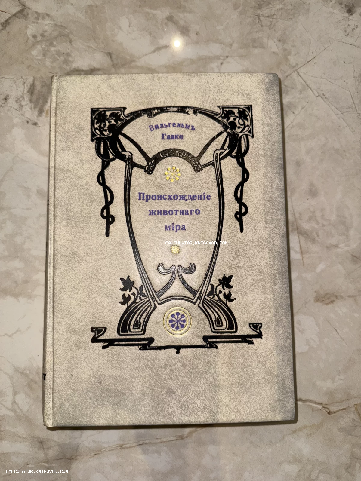 Старинная книга Вильгельма Гааке «Происхождение животного мира» в светлом переплете с изящным черным орнаментом в стиле модерн.