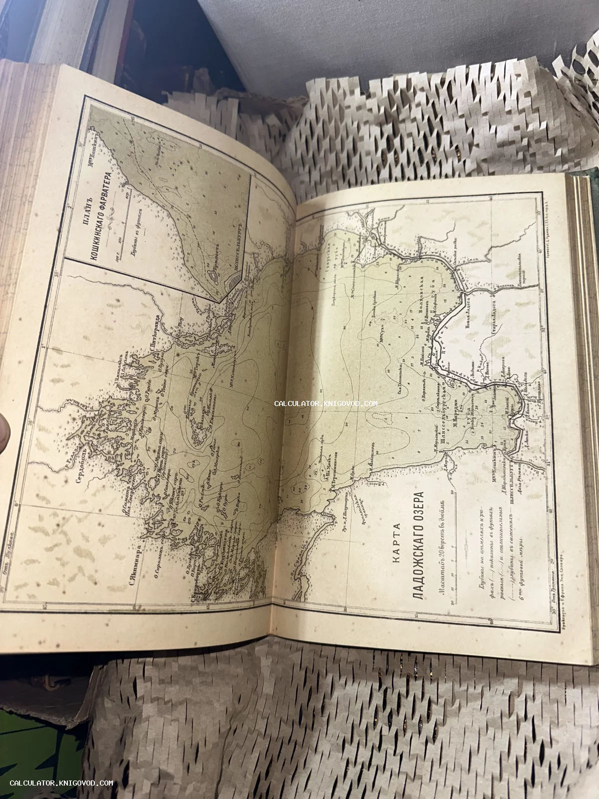 Разворот старинной книги с литографированной картой Ладожского озера и навигационным планом Кошкинского фарватера.