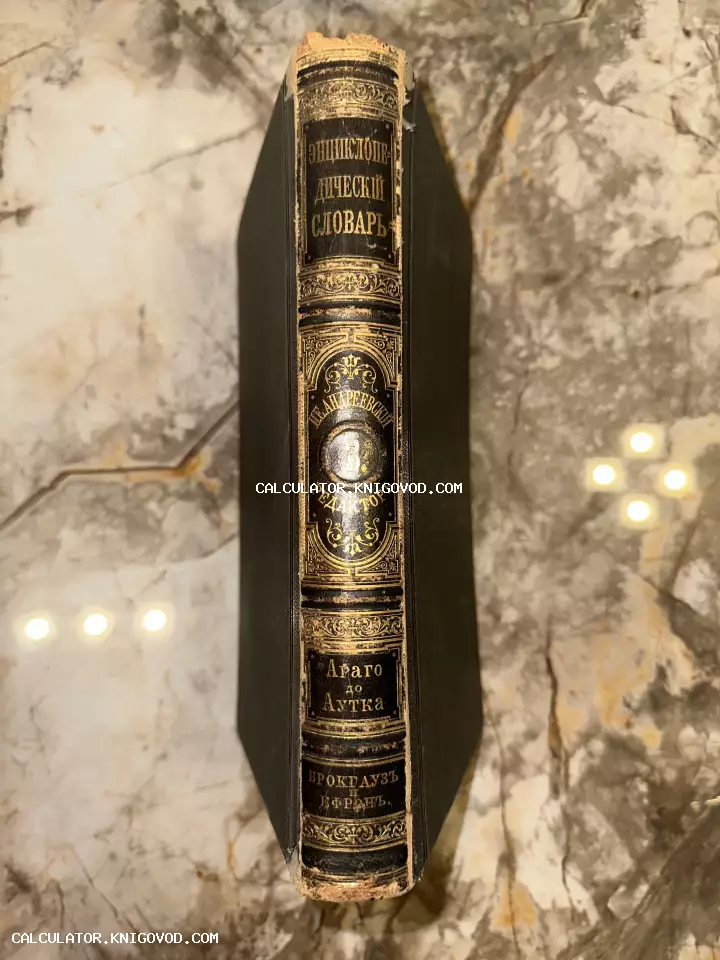 Корешок антикварной книги в кожаном переплете с золотым тиснением на фоне мрамора