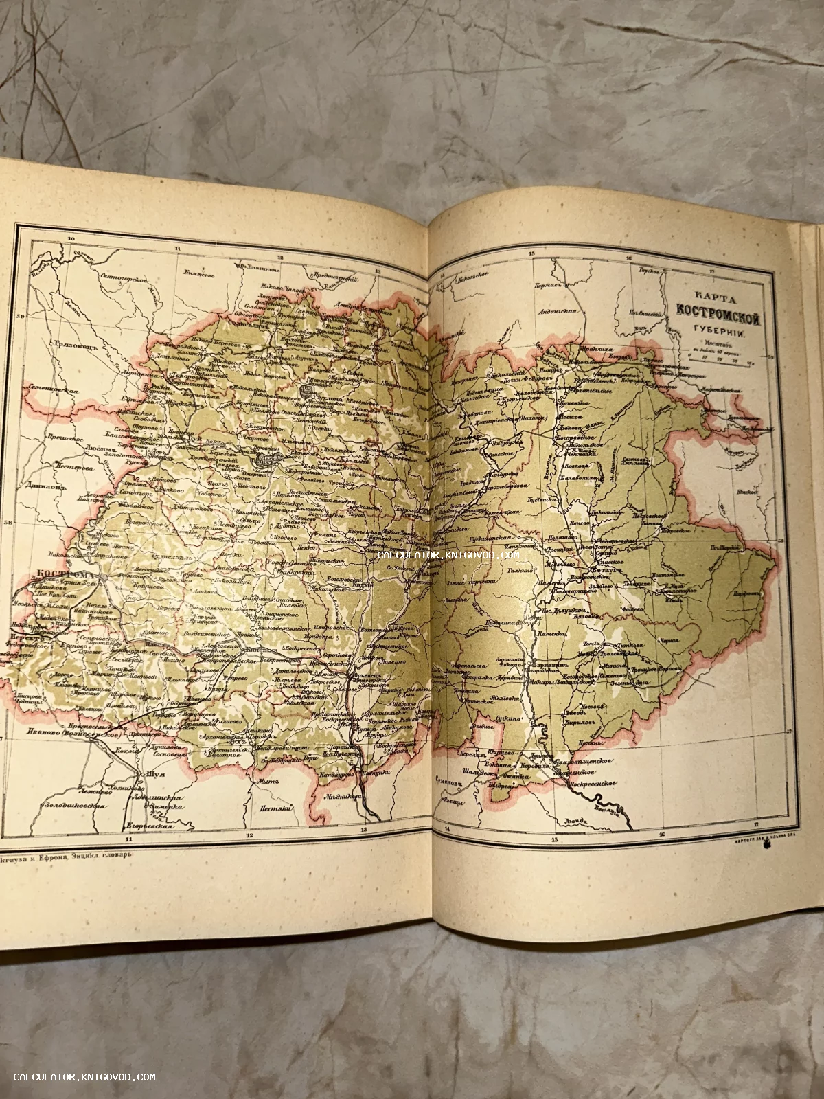 Разворот старинной книги с подробной цветной картой Костромской губернии конца XIX века из энциклопедии.