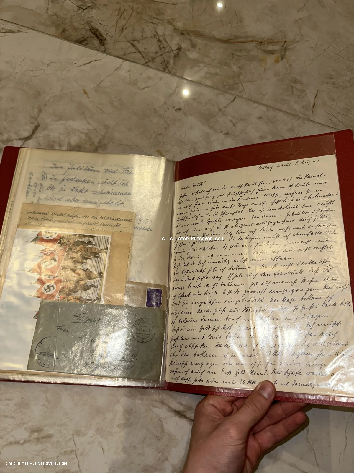 Развернутая папка с рукописным письмом на немецком языке, почтовым конвертом Feldpost и открыткой периода Второй мировой войны.