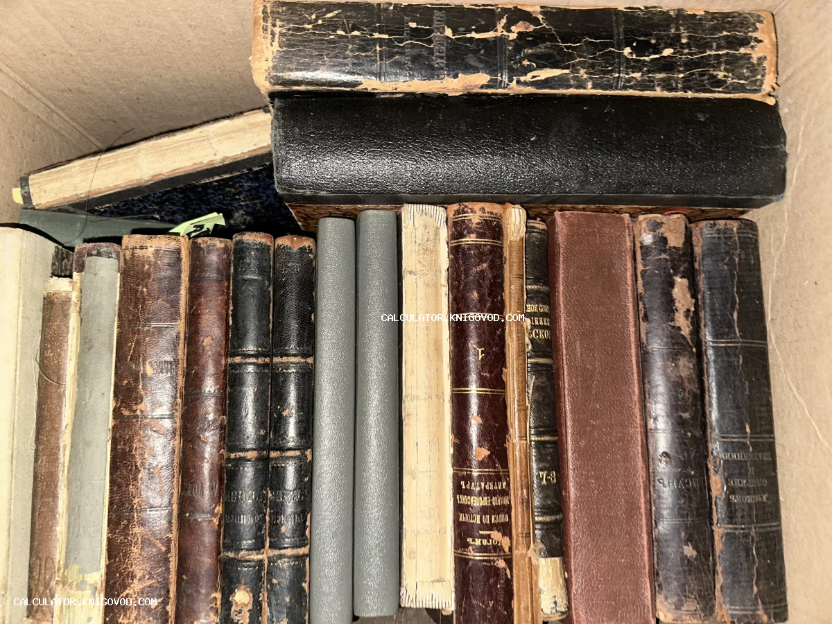 Старинные книги с потертыми кожаными и тканевыми корешками, сложенные в коробку.