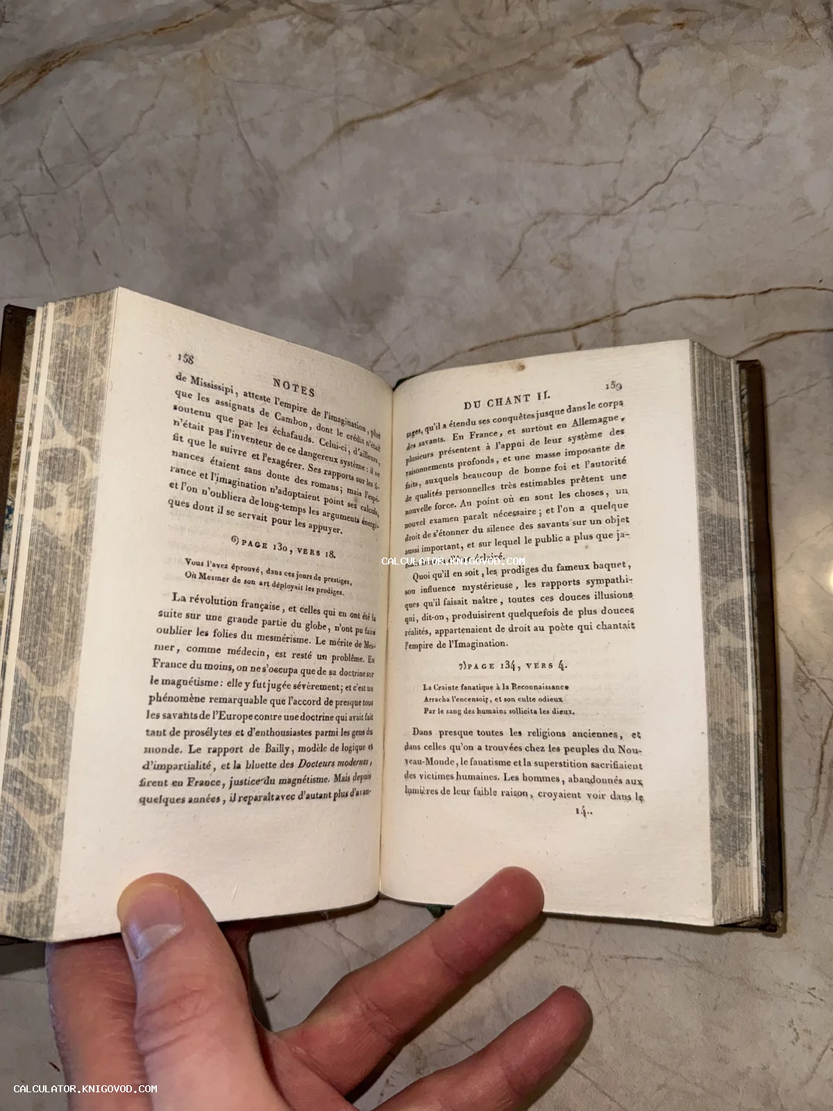 Разворот старинной книги на французском языке с типографским текстом, примечаниями и следами времени на бумаге.