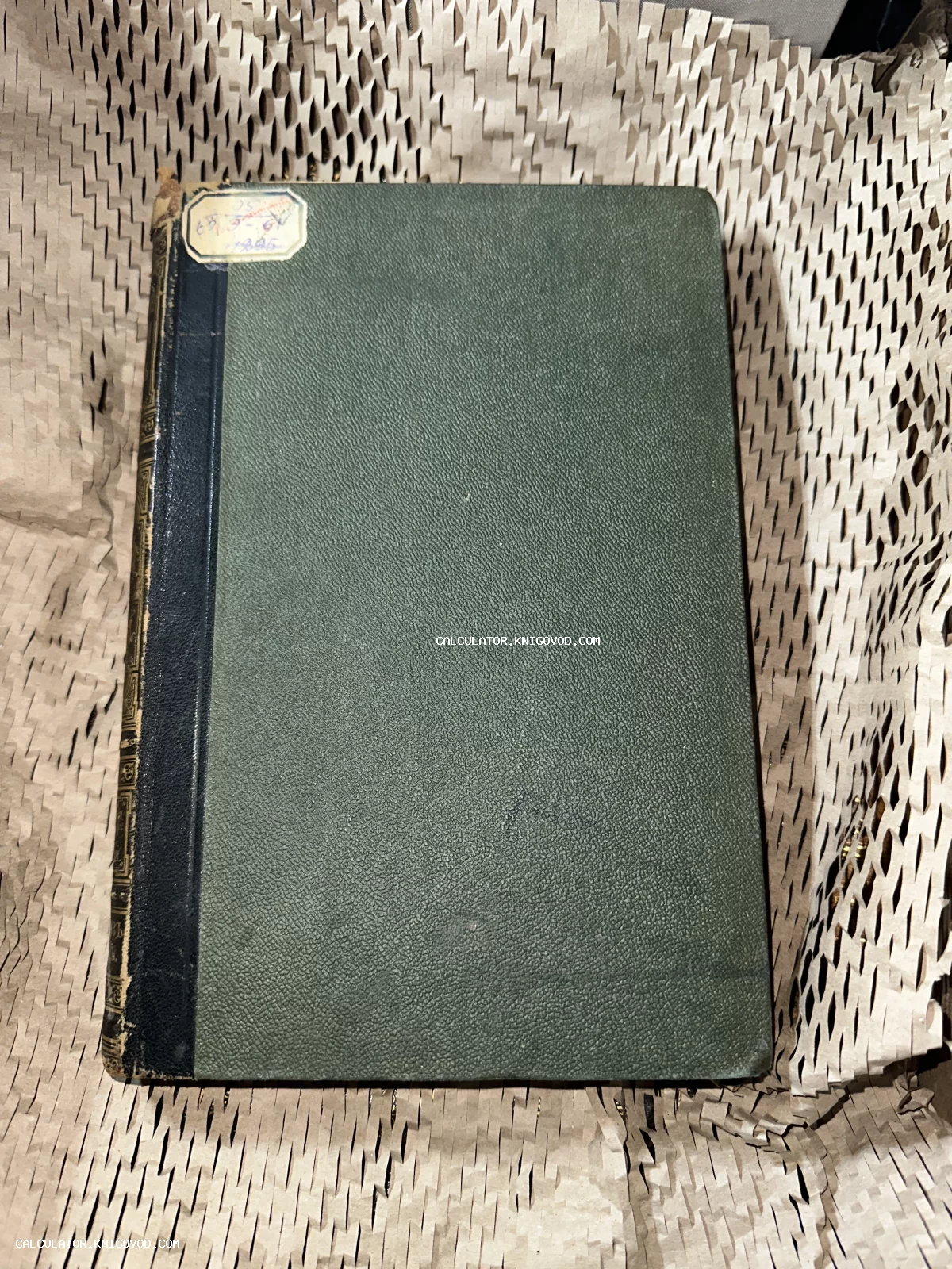 Антикварная книга с темно-зеленой текстурированной обложкой, черным тисненым корешком и старинной бумажной наклейкой.