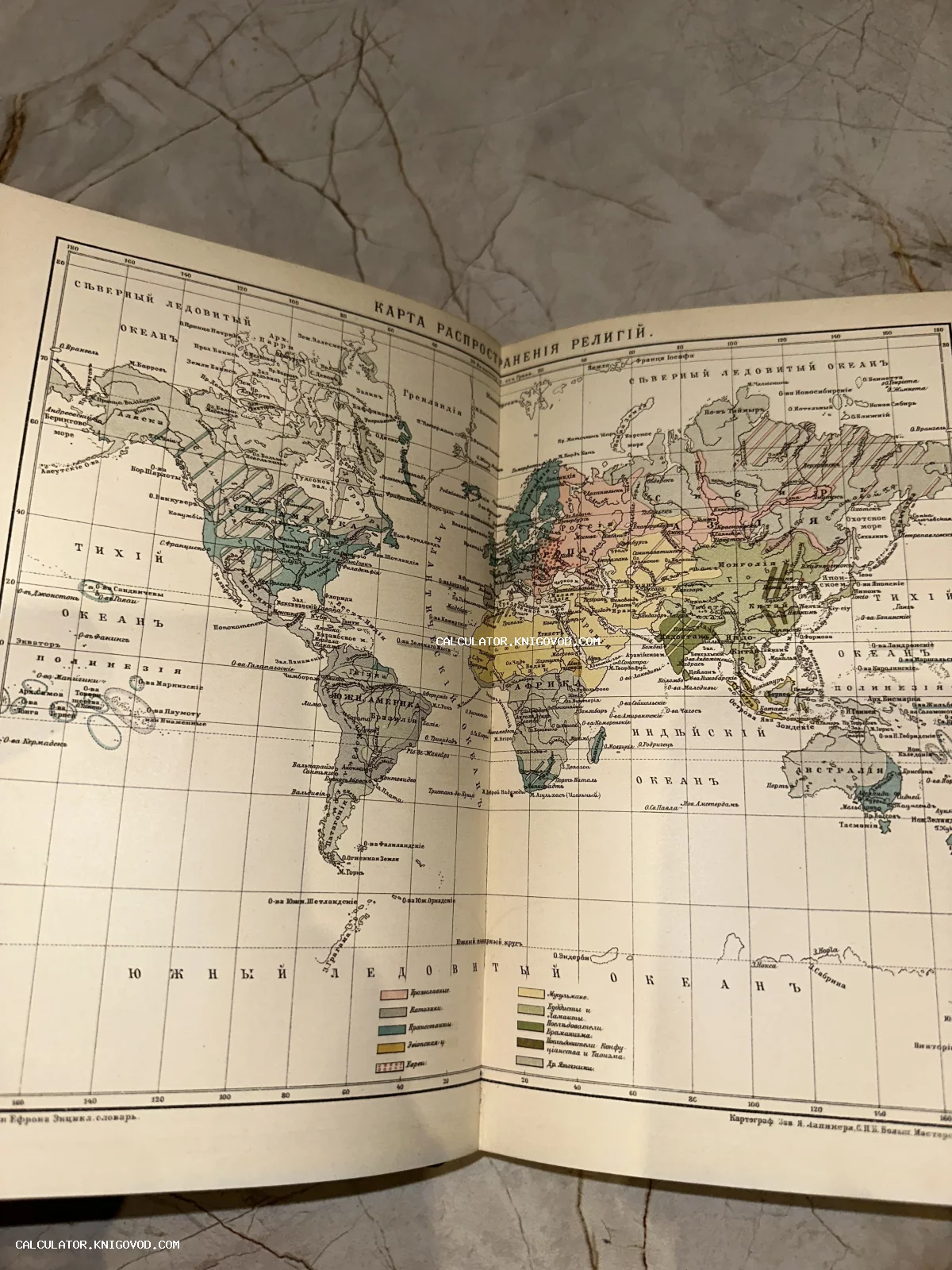 Разворот старинной книги с цветной картой мира, отображающей географию распространения религий в начале XX века.