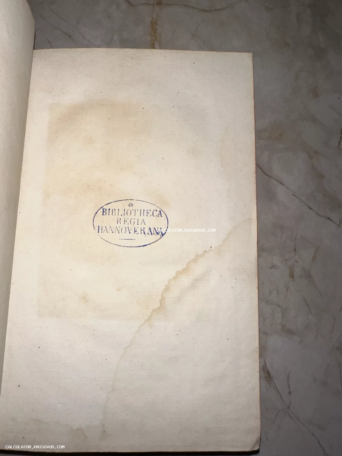 Старинная книжная страница с синим овальным штампом Bibliotheca Regia Hannoverana на пожелтевшей бумаге со следами времени.