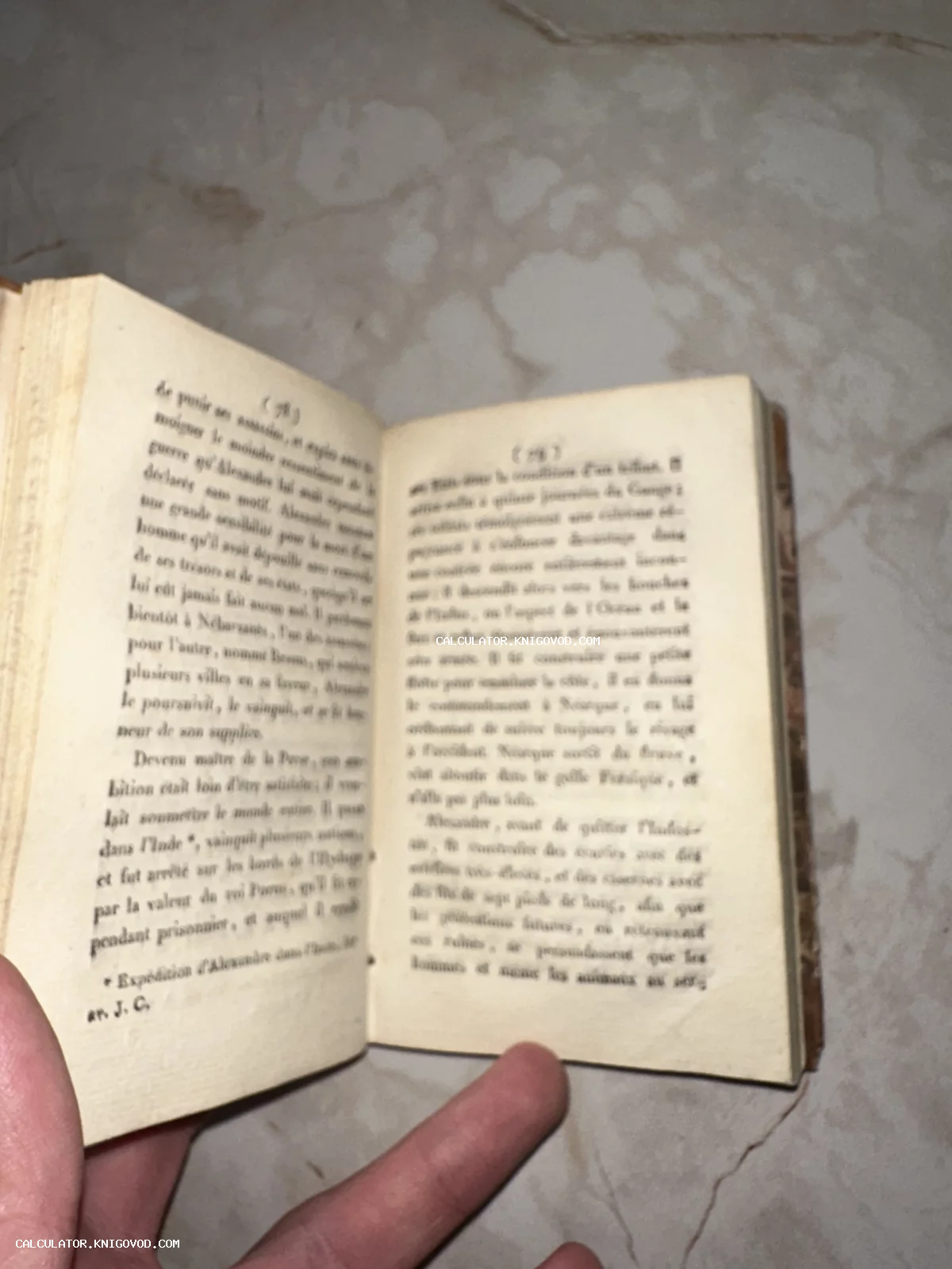 Разворот старинной книги на французском языке с пожелтевшими страницами, текст о походах Александра Македонского.