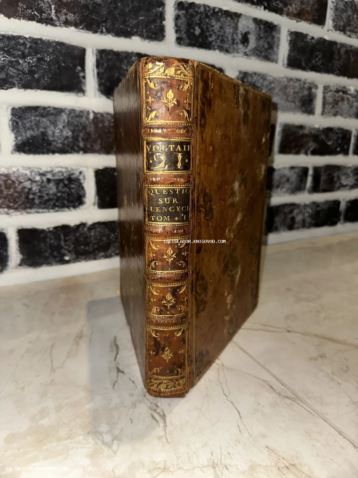 Старинная книга Вольтера в кожаном переплете с золотым тиснением на корешке.