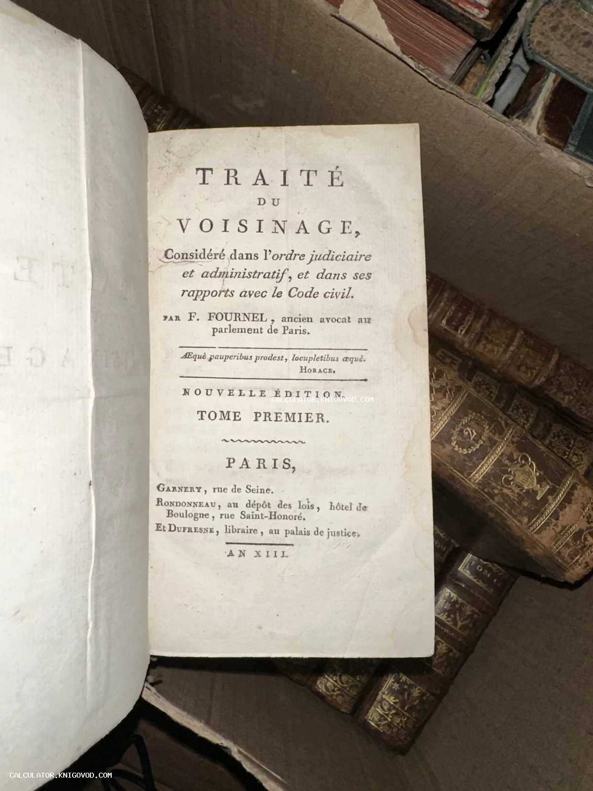 Титульный лист старинной французской книги Traité du Voisinage на фоне других томов в кожаных переплетах.