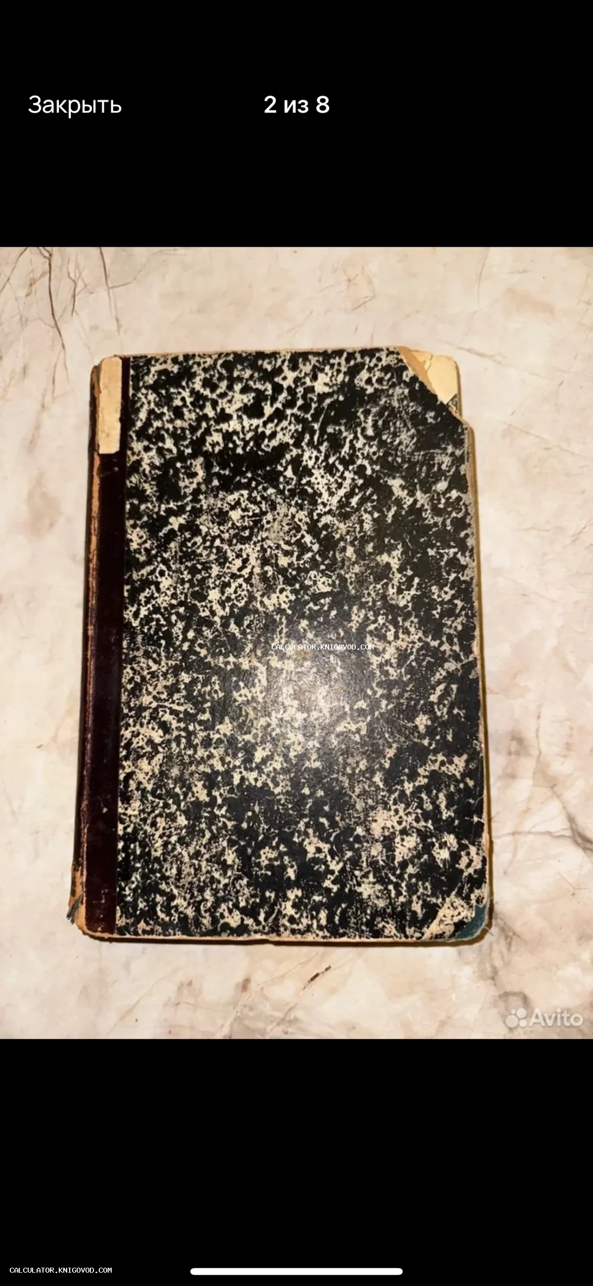 Старинная книга с характерным черно-белым мраморным узором на обложке и темным изношенным корешком.