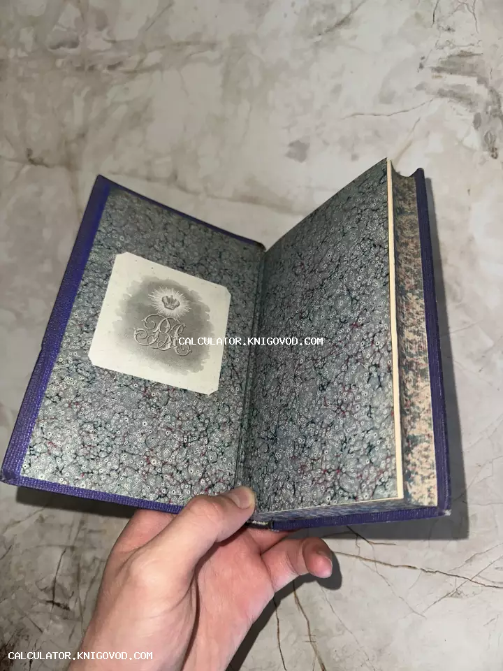 Раскрытая старинная книга с фиолетовым переплетом, мраморным форзацем и наклеенным экслибрисом с короной и монограммой.