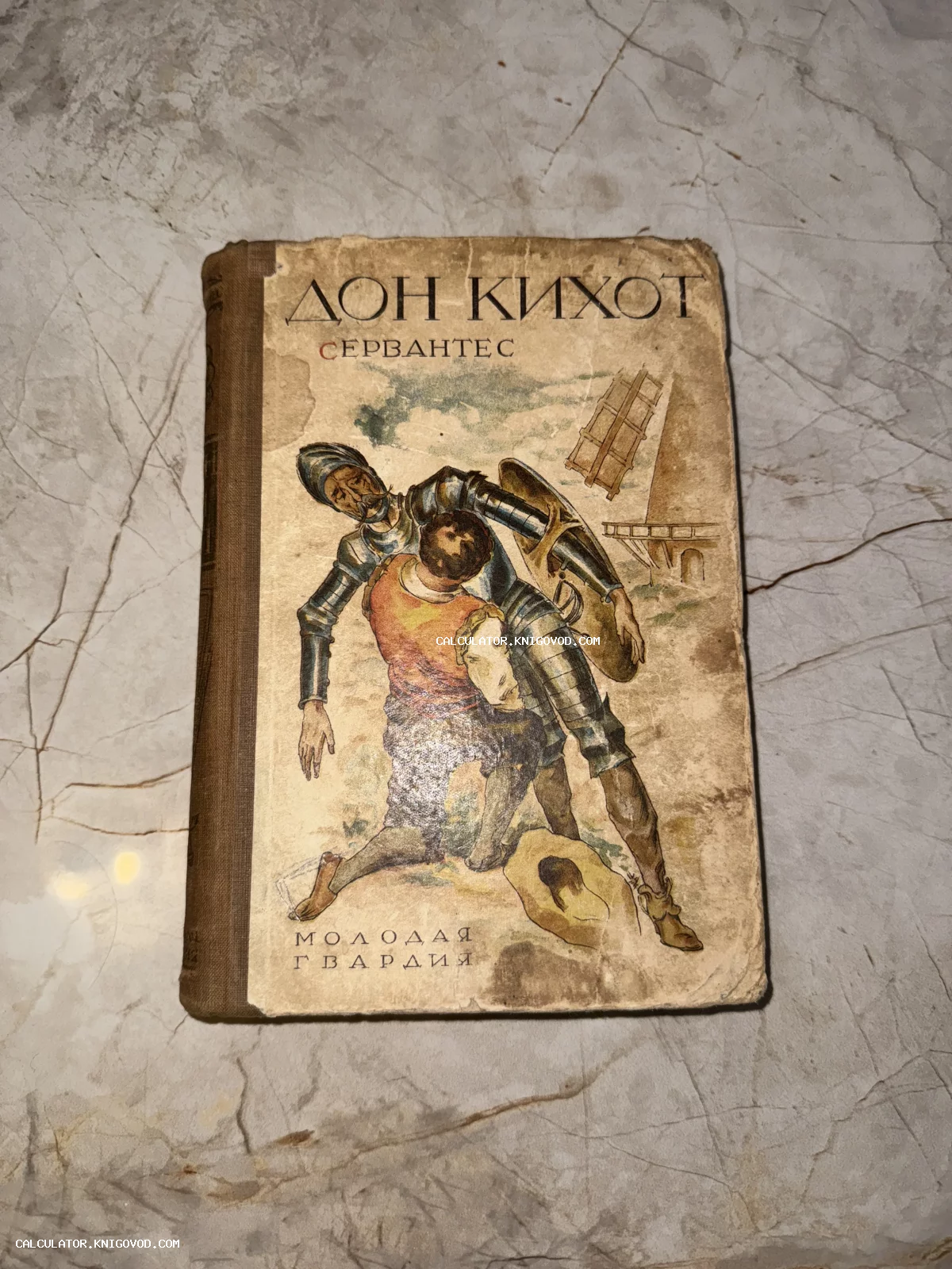 Старая книга «Дон Кихот» Сервантеса с иллюстрацией рыцаря в доспехах и Санчо Пансы на фоне мельницы.