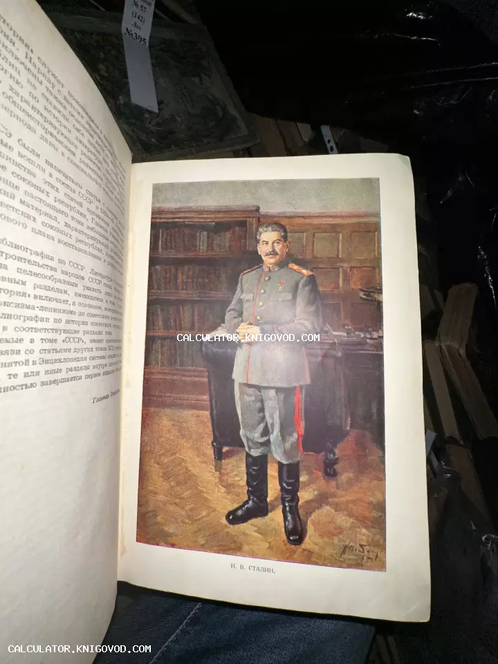 Разворот старой книги с цветной иллюстрацией, изображающей Иосифа Сталина в военной форме в рабочем кабинете.
