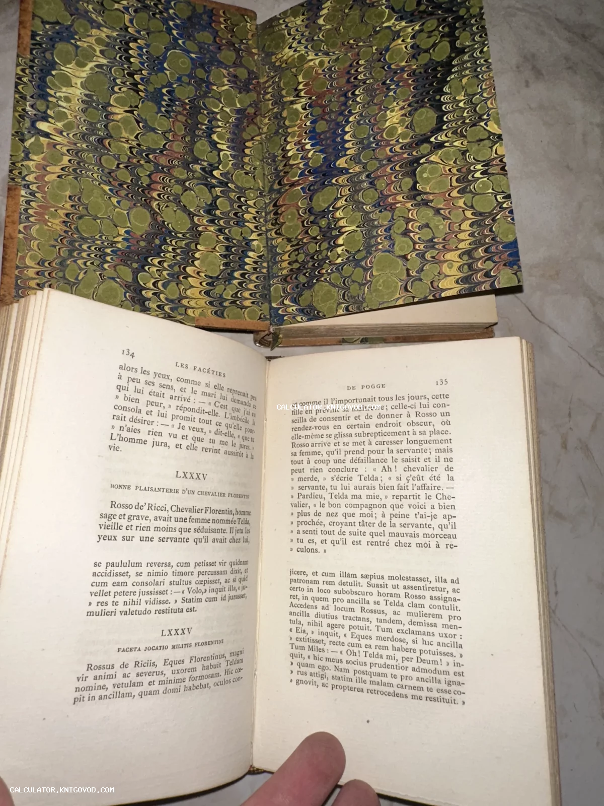 Разворот антикварной книги с текстом на французском и латыни, украшенный форзацем с мраморной бумагой ручной работы.