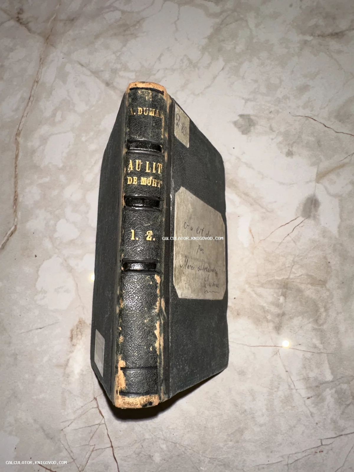 Старинная книга Александра Дюма Au lit de mort в темном кожаном переплете с золотым тиснением на корешке.