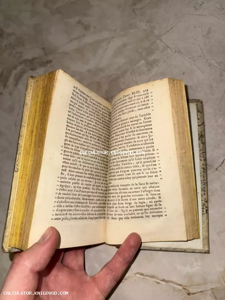 Разворот старинной французской книги с пожелтевшими страницами и антикварным шрифтом.