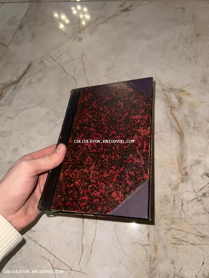 Антикварная книга с мраморным узором на обложке и кожаным корешком в руке человека.