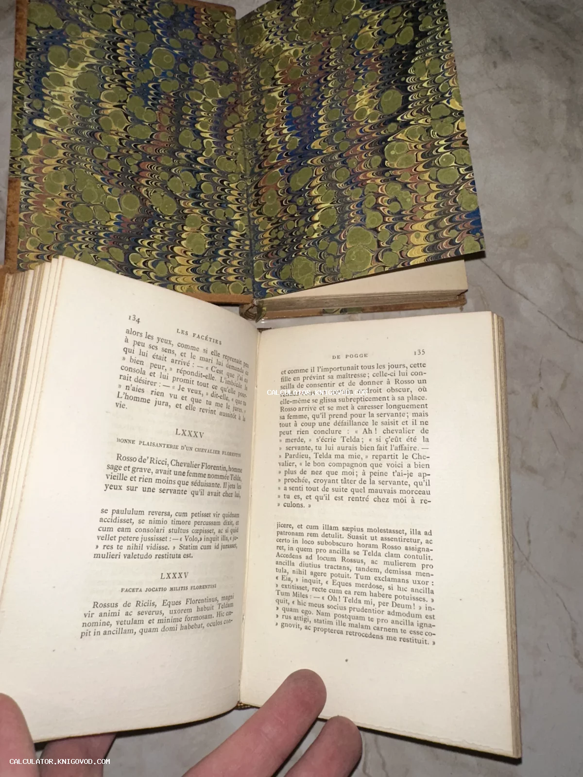 Разворот старинной книги с печатным текстом и декоративным форзацем из мраморной бумаги ручной работы.