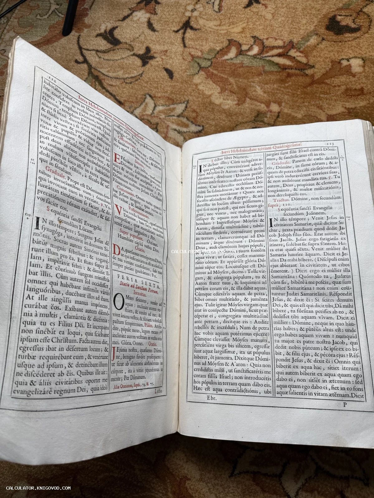 Разворот антикварной книги с двухколоночным текстом на латыни, напечатанным черным и красным шрифтом на пожелтевшей бумаге.